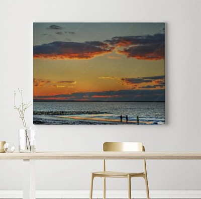 Obraz na płótnie Zachód słońca na oceanie z sylwetką ludzi na brzegu