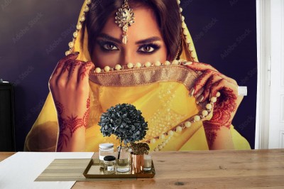 Fototapeta Piękna indyjska dziewczyna  Młoda hinduska modelka z tatuażową mehndi i biżuterią kundan  Tradycyjny indyjski kostium żółty sari  Hinduska lub muzułmanka zakrywa twarz