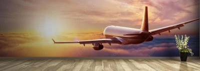 Fototapeta Pasażerski samolot komercyjny na tle zachodzącego słońca