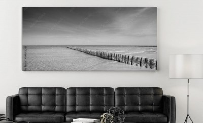 Obraz na płótnie Czarno-białe zdjęcie drewnianego falochronu na plaży 