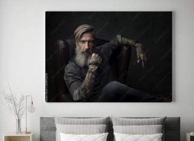 Obraz na płótnie Portret wytatuowany brodaty mężczyzna siedzi na fotelu