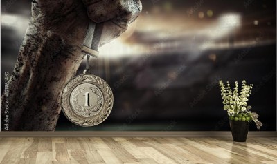 Fototapeta Męska ręka trzyma złoty medal na stadionie