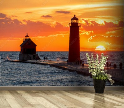 Fototapeta latarnia morska o zachodzie słońca z sylwetkami ludzi