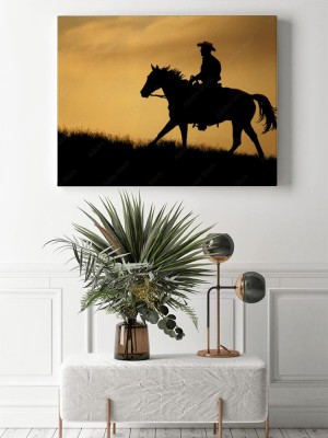 Obrazy do salonu Sylwetka kowboja na koniu podczas zachodzącego słońca