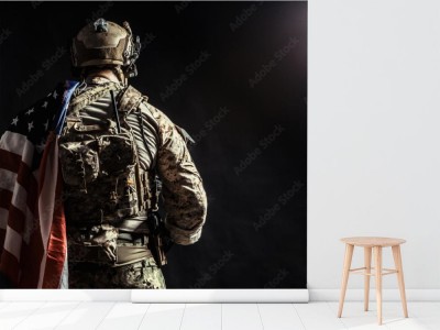 Fototapeta Żołnierz trzyma karabin maszynowy z flagą USA