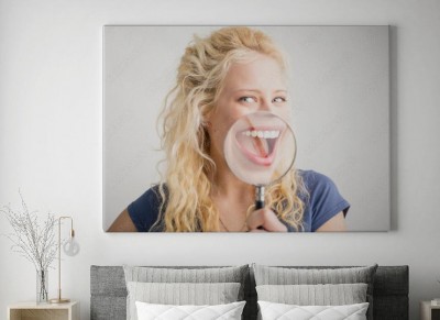 Obraz na płótnie Kobieta pokazuje uśmiech przez szkło powiększające